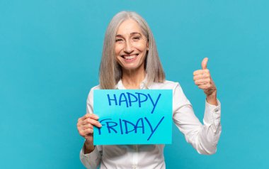 'Mutlu Cuma' tabelası olan orta yaşlı kadın.