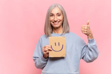 Gülümseme işareti olan orta yaşlı kadın