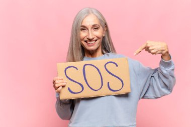 SOS sözcüğüyle orta yaşlı bir kadın.
