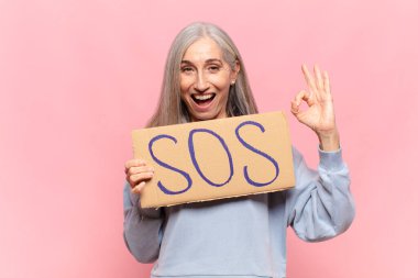 SOS sözcüğüyle orta yaşlı bir kadın.