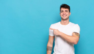 Mavi arka planda genç yakışıklı adam