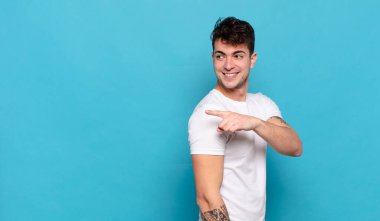 Mavi arka planda genç yakışıklı adam