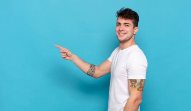 Mavi arka planda genç yakışıklı adam