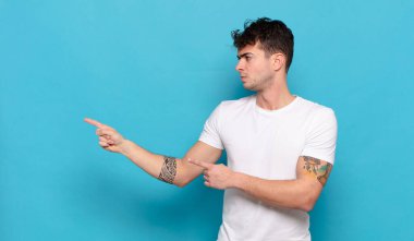 Mavi arka planda genç yakışıklı adam