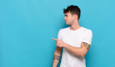 Mavi arka planda genç yakışıklı adam