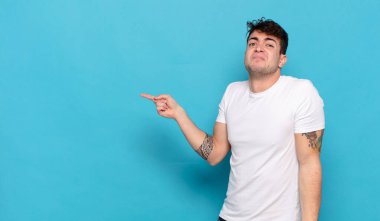 Mavi arka planda genç yakışıklı adam