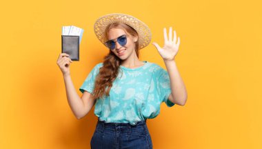 Gülümsüyor ve dost canlısı görünüyor, 5 ya da 5 numarayı gösteriyor, el önde, geriye doğru sayıyor.