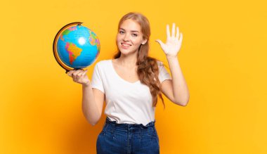 Gülümsüyor ve dost canlısı görünüyor, 5 ya da 5 numarayı gösteriyor, el önde, geriye doğru sayıyor.