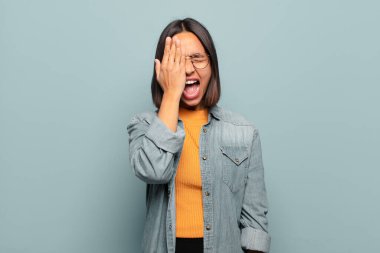 Genç İspanyol kadın uykulu görünüyor, sıkılmış ve esniyor, baş ağrısı ve yüzünün yarısını kaplayan bir eliyle