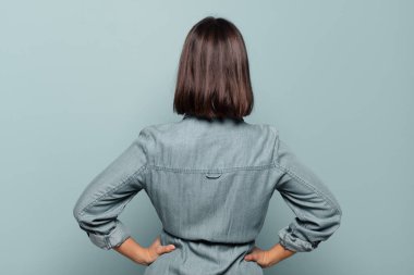 Genç İspanyol kadın kafası karışık ya da dolu ya da şüphe ve soru dolu, merak ediyor, elleri kalçasında, dikiz aynasından