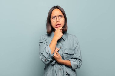 Ağzı ve gözleri sonuna kadar açık, eli çenesinde genç İspanyol bir kadın. Hoş olmayan bir şok geçiriyor.