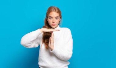 Sarışın, güzel bir kadın ciddi, sert, kızgın ve hoşnutsuz görünüyor.