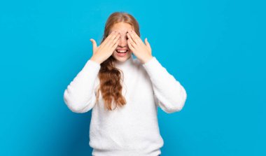 Sarışın, güzel bir kadın gülümsüyor ve mutlu hissediyor, iki eliyle gözlerini kapatıyor ve inanılmaz bir sürpriz bekliyor.