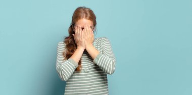 Sarışın, güzel bir kadın üzgün, hayal kırıklığına uğramış, gergin ve depresif, iki eliyle yüzünü kaplayan, ağlayan
