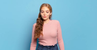 Sarışın, güzel, aptal ve komik bir kadın. Şaşı bakışlı, şakacı ve şakacı.