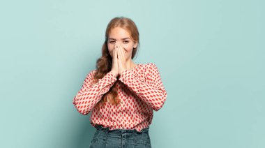 Sarışın, güzel bir kadın mutlu, neşeli, şanslı ve şaşkın görünüyor. İki eliyle ağzını kapatıyor.