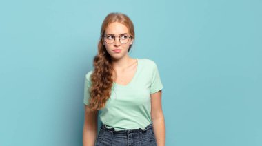 Sarışın, güzel bir kadın üzgün, üzgün ya da kızgın ve olumsuz bir tavır takınıyor, anlaşmazlık içinde kaşlarını çatıyor.