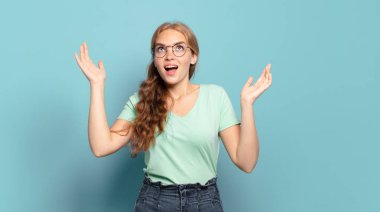 Sarışın, güzel bir kadın kendini mutlu, şaşkın, şanslı ve şaşırmış hissediyor. Zaferi iki eli havada kutluyor.