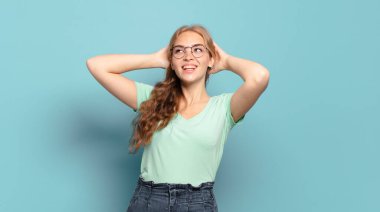 Güzel sarışın kadın gülümsüyor ve rahatlıyor, tatmin oluyor ve kaygısız, neşeli ve rahatlatıcı.