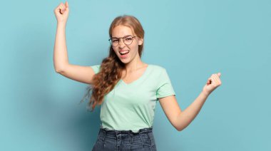 Sarışın, güzel bir kadın muzaffer bir şekilde bağırıyor. Heyecanlı, mutlu ve şaşkın bir kazanan gibi görünüyor.