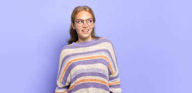 Sarışın, güzel bir kadın şaşkın, mutlu, şaşkın ve şaşırmış hissediyor, ağzı açık bir şekilde yana bakıyor.