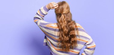 Sarışın, güzel bir kadın bilgisiz ve kafası karışık, bir çözüm düşünüyor, eli kalçasında, diğeri kafasında, dikiz aynasından.