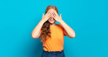 Sarışın, güzel bir kadın gülümsüyor ve mutlu hissediyor, iki eliyle gözlerini kapatıyor ve inanılmaz bir sürpriz bekliyor.