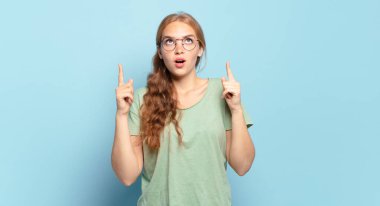 Sarışın, güzel bir kadın. Korkmuş ve ağzı açık. Şok olmuş ve şaşırmış bir şekilde yukarı bakıyor.