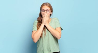 Sarışın, güzel bir kadın endişeli, üzgün ve korkmuş, elleriyle ağzını kapatmış, endişeli ve berbat görünüyor.