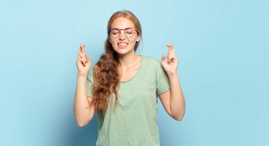 Sarışın, güzel bir kadın gergin ve umutlu. Dua ediyor ve şans diliyor.