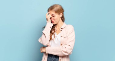 Sarışın, güzel bir kadın stresli, mutsuz ve hayal kırıklığına uğramış, alınlı ve şiddetli baş ağrısı çeken.