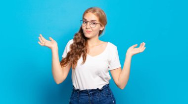 Sarışın, güzel bir kadın şaşkın ve şaşkın hissediyor, şüpheci, farklı seçenekleri tartıyor veya komik bir ifadeyle seçiyor. 