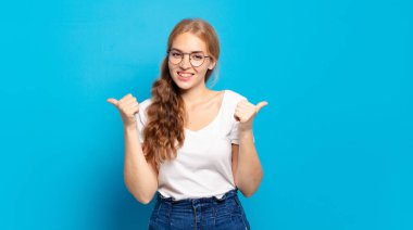 Sarışın, güzel bir kadın neşeyle gülümsüyor ve mutlu görünüyor, kaygısız ve pozitif hissediyor.