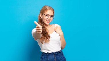 Sarışın, güzel bir kadın gururlu, tasasız, kendinden emin ve mutlu, olumlu gülümsüyor.