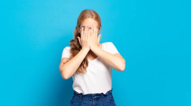 Sarışın, güzel bir kadın üzgün, hayal kırıklığına uğramış, gergin ve depresif, iki eliyle yüzünü kaplayan, ağlayan