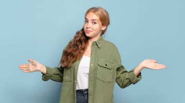 blonde pretty woman feeling clueless and confused, having no idea, absolutely puzzled with a dumb or foolish look