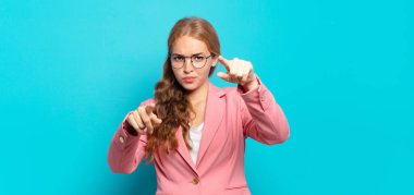 Sarışın, güzel bir kadın kamerayı iki parmağıyla ve kızgın bir ifadeyle sana görevini yapmanı söylüyor.