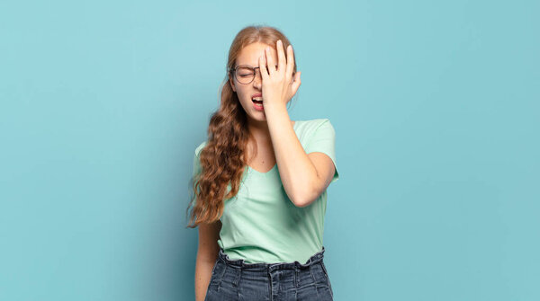 блондинка красивая женщина выглядит сонной, скучающей и зевающей, с головной болью и одной рукой, покрывающей половину лица