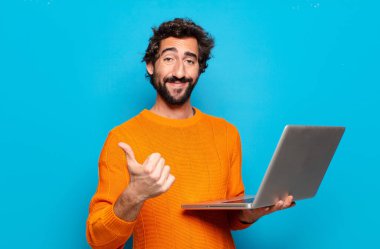 Genç sakallı adam dizüstü bilgisayar tutuyor. Sosyal medya kavramı