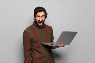 Laptoplu genç sakallı adam.