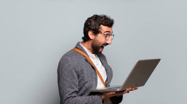 Genç sakallı ve bilgisayarlı çılgın iş adamı.