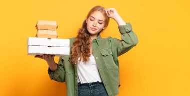 Genç sarışın kadın fast food 'u götürüyor.