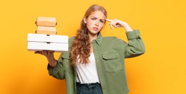 Genç sarışın kadın fast food 'u götürüyor.