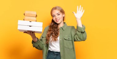 Genç sarışın kadın fast food 'u götürüyor.