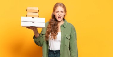 Genç sarışın kadın fast food 'u götürüyor.