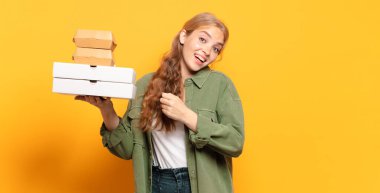 Genç sarışın kadın fast food 'u götürüyor.