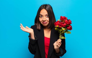 Genç ve güzel bir kadın elinde bir buket gül tutuyor.