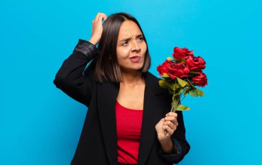 Genç ve güzel bir kadın elinde bir buket gül tutuyor.