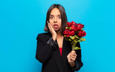 Genç ve güzel bir kadın elinde bir buket gül tutuyor.