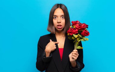 Genç ve güzel bir kadın elinde bir buket gül tutuyor.